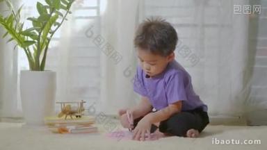 快乐的亚洲klid<strong>小</strong>男孩在家里的磁板上写在地毯上。有趣的孩子玩磁力画板。教育学习绘画概念。前景